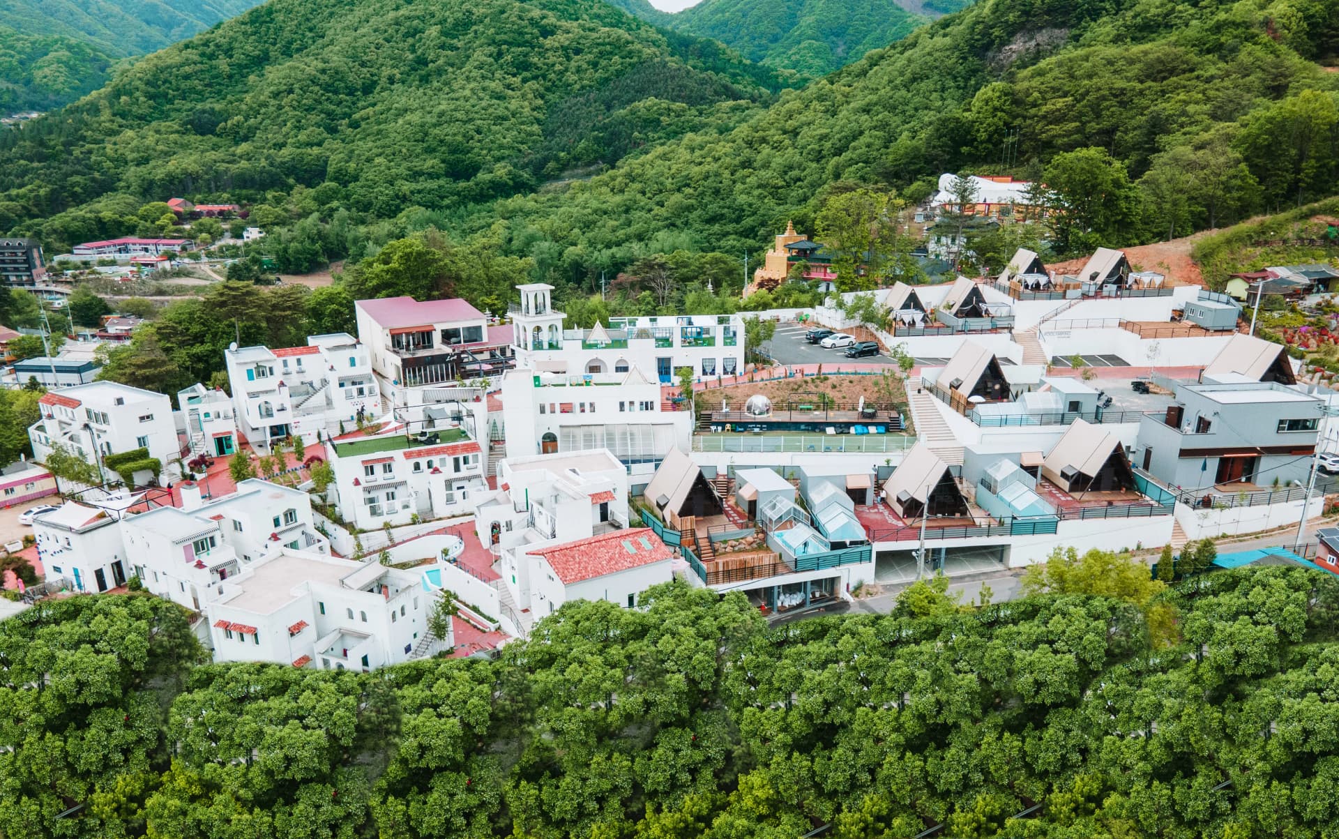 초록 산에 둘러싸인 마을 항공뷰